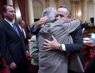 Photo of men in suits hugging after a victorious legal proceeding.