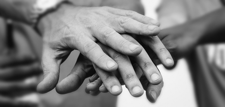 Close up image of a families hands layered on top of each other