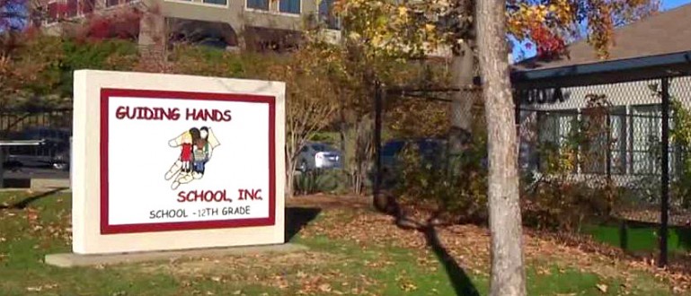 Image of the Guiding Hands School sign in front of the building