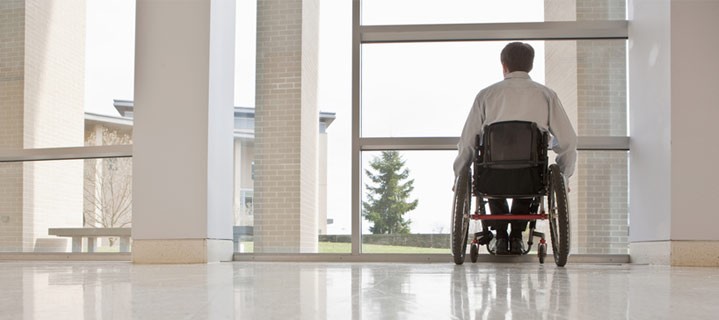 Man in wheelchair looking out window