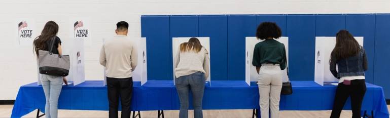 Several people at a voting booth