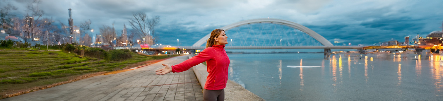 A latina woman with a red fleece jacket spreading her arms.
