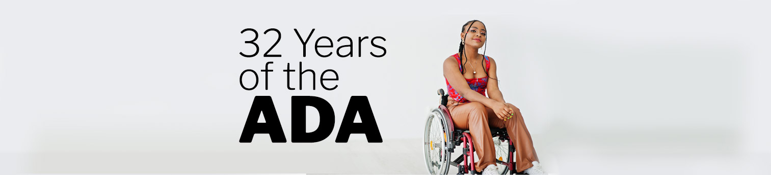 32 Years of the ADA - Photo of a black woman smiling in a wheel chair against a plain background.
