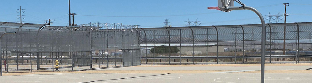 The outsite recreation are. It is bare and has fences all around it.