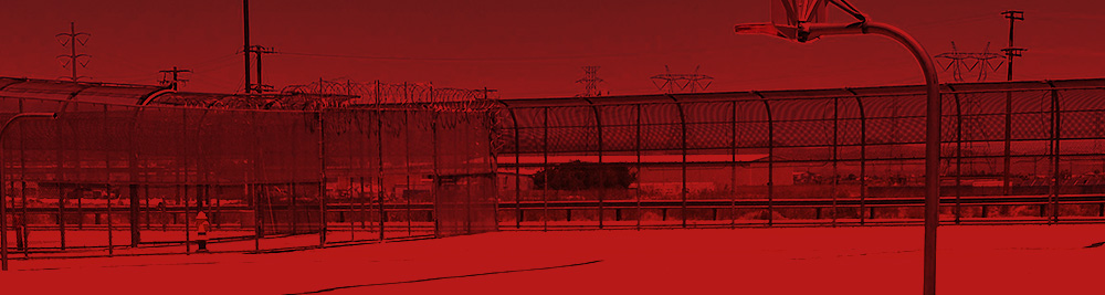 The outsite recreation are. It is bare and has fences all around it. the image is tinted in red.