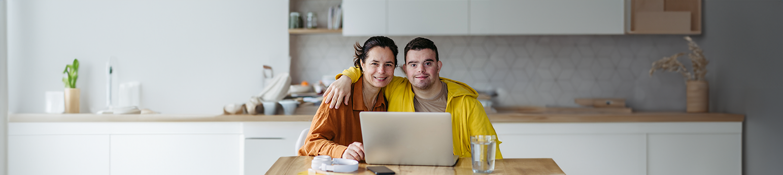 A smiling mother and her son with a laptop.