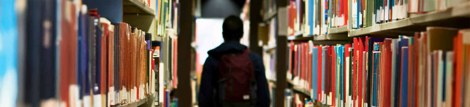 A student in a isle of file folders on shelves.