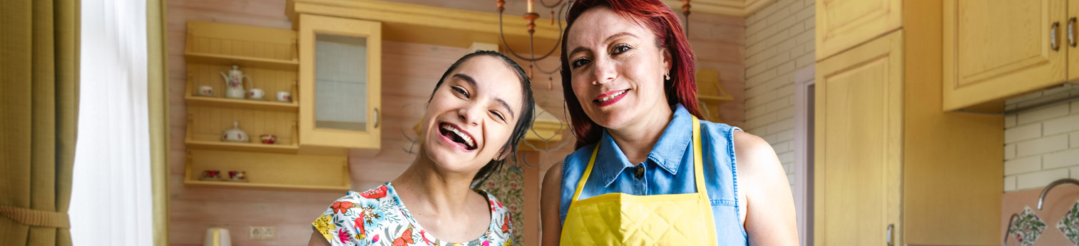 A mother and daughter cooking in the kitchen. The daughter has a developmental disability.
