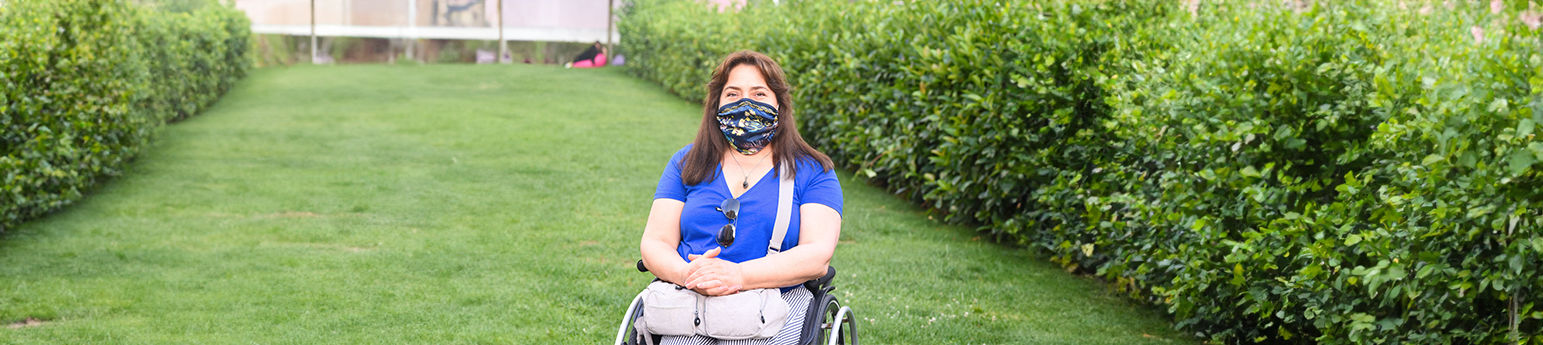 A latina woman in a wheelchair wearing a mask.