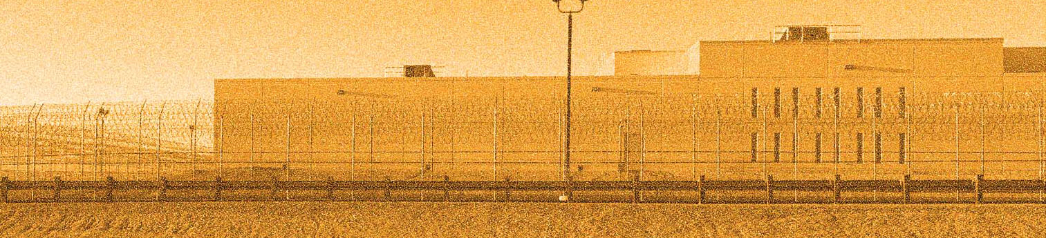 Front of the newly opened California City ICE facility. A lone building surrounded by barbed wire.