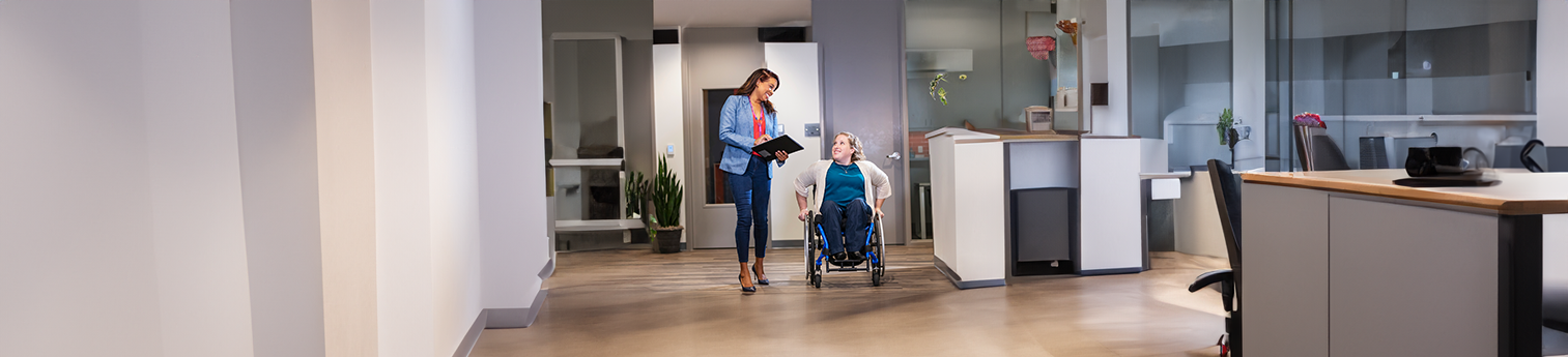 An female advocate next to a woman in a wheelchair.