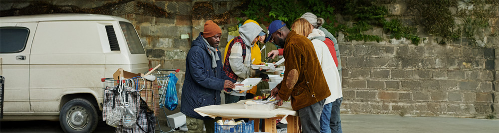 Unhoused people getting food from volunteers.