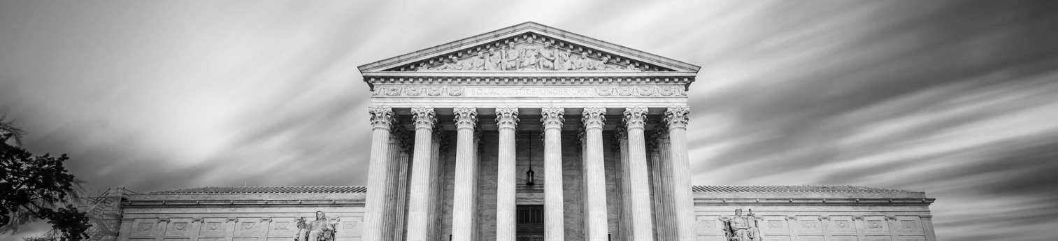 Black and white photo of United States Supreme Court Building in Washington DC, USA at dusk.
