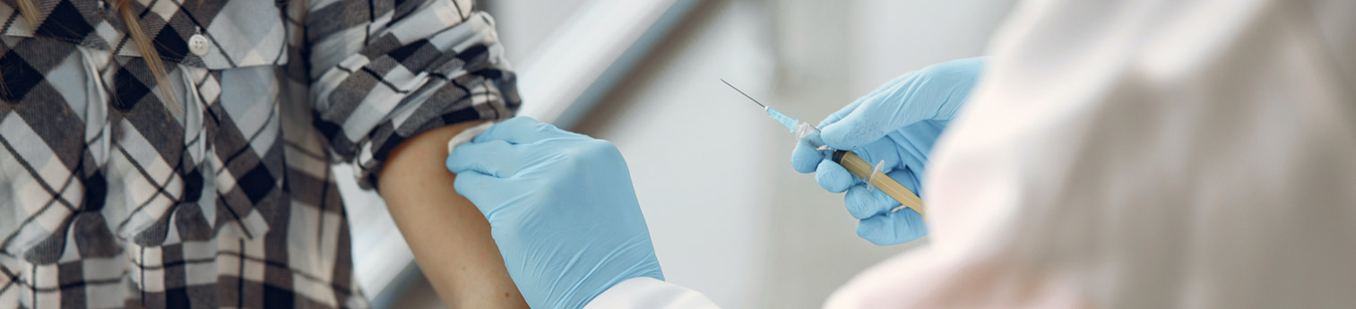 A young person receiving a vaccine shot at a clinic.