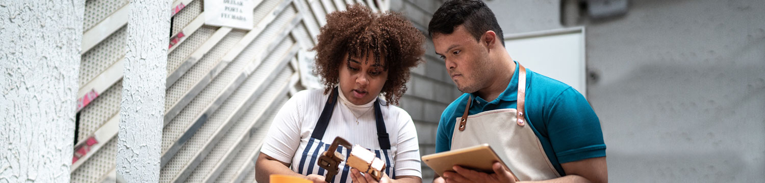 A man and a woman with a disability working at a warehouse.