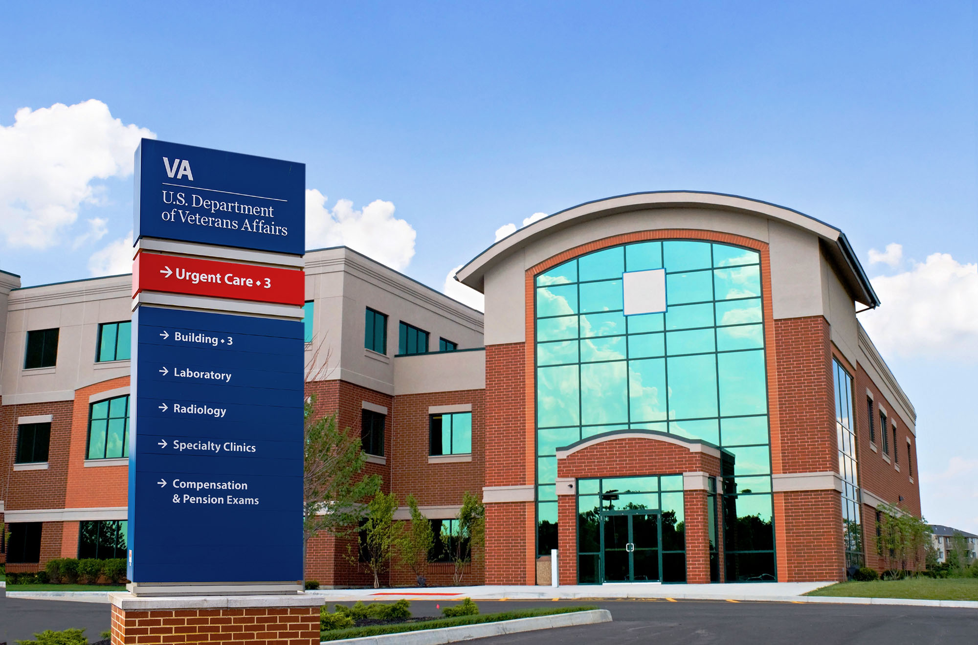 Front of a VA Hospital with the VA sign in front.