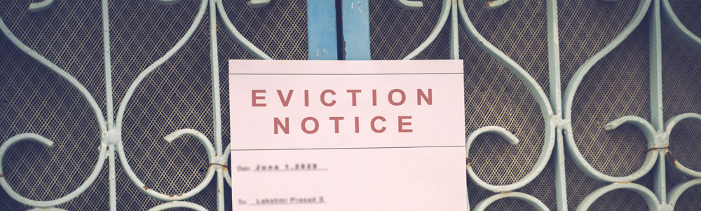 An apartment gate with an eviction notice tapped on the front.