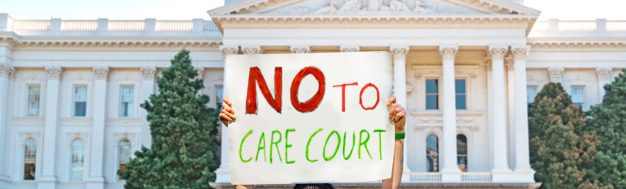 Photo of a person holding up a sign in front of California state capital. The sign says NO to Care Court