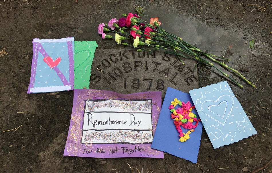 Remembrance Ceremony there photo of artwork placed around the stone identifying our peers who died at the Stockton State Hospital.