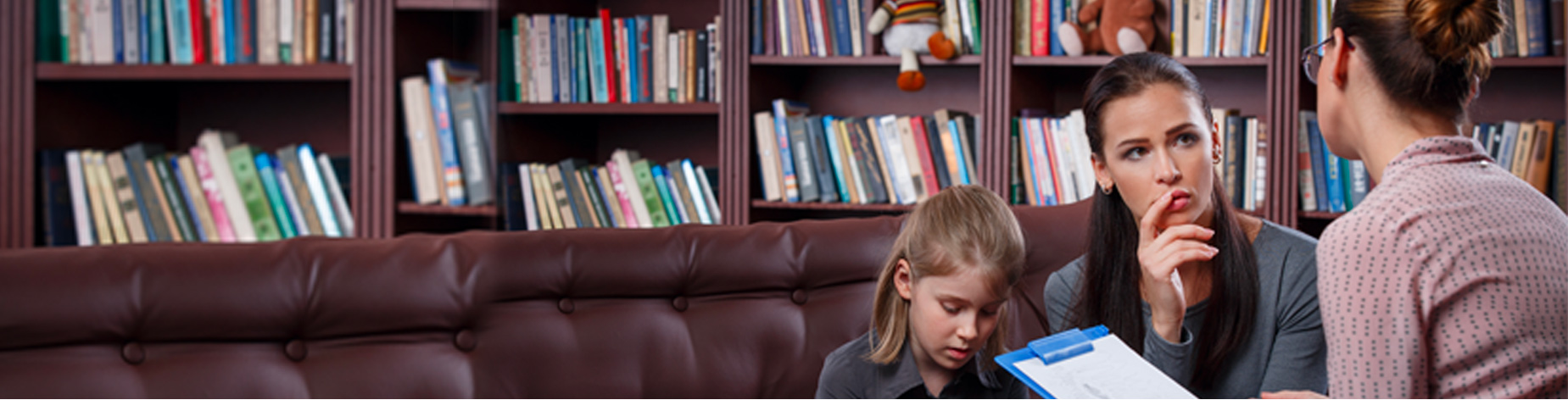 Photo of a parent with her child discuss with a school teacher the benefits she should be getting