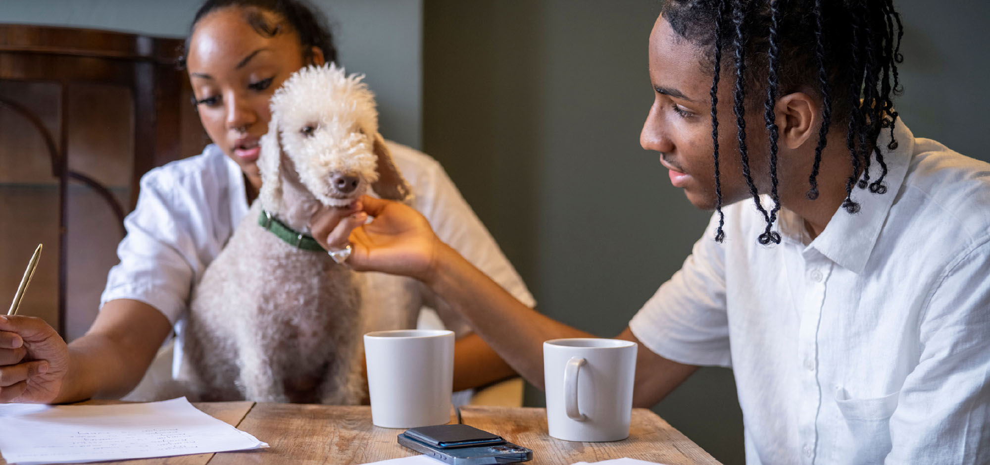 A black female student and a black male student doing their homework at the kitchen table.
