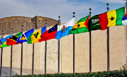 Photo of many flag poles with different nations flags in front of UN building.