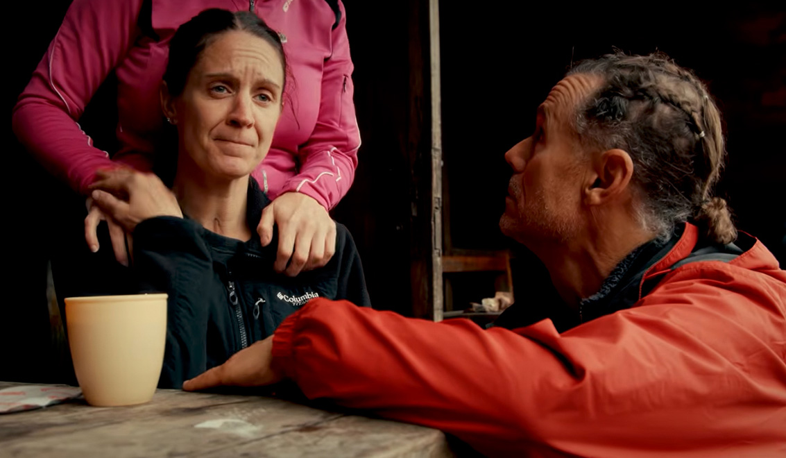 Friends comforting each other, with their hands on Erika.