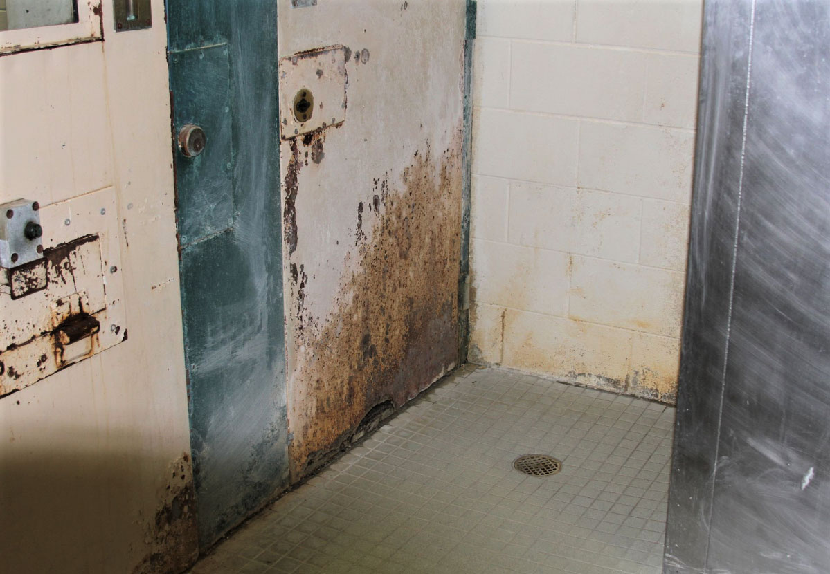 Photo showing mold and rust in a bathroom shower in the dorm.