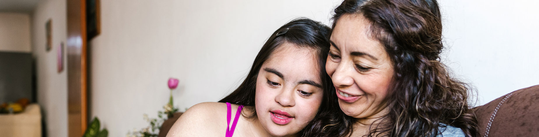 Image of mother and daughter smiling. The daughter has a mental disability.
