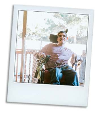 Photo of a man with a disability in a mobile chair about to enter his home.