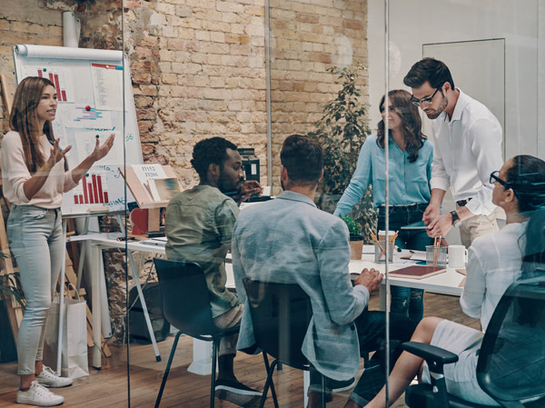 Group of employees in a conference room discussing different topics.