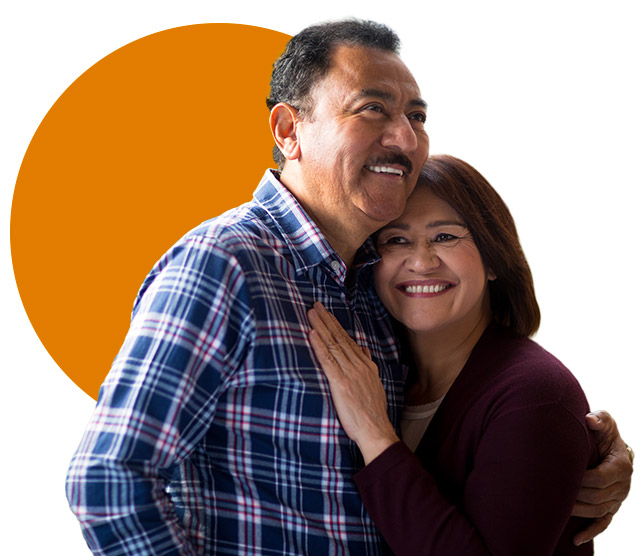 Photo of an elderly couple hugging each other and smiling.