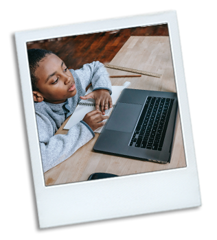 Photo of a young boy working on his laptop. He is in a online class.