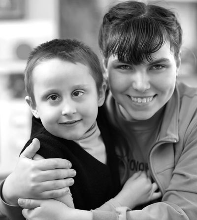 Photo of a woman hugging a young boy who has a mental disability.