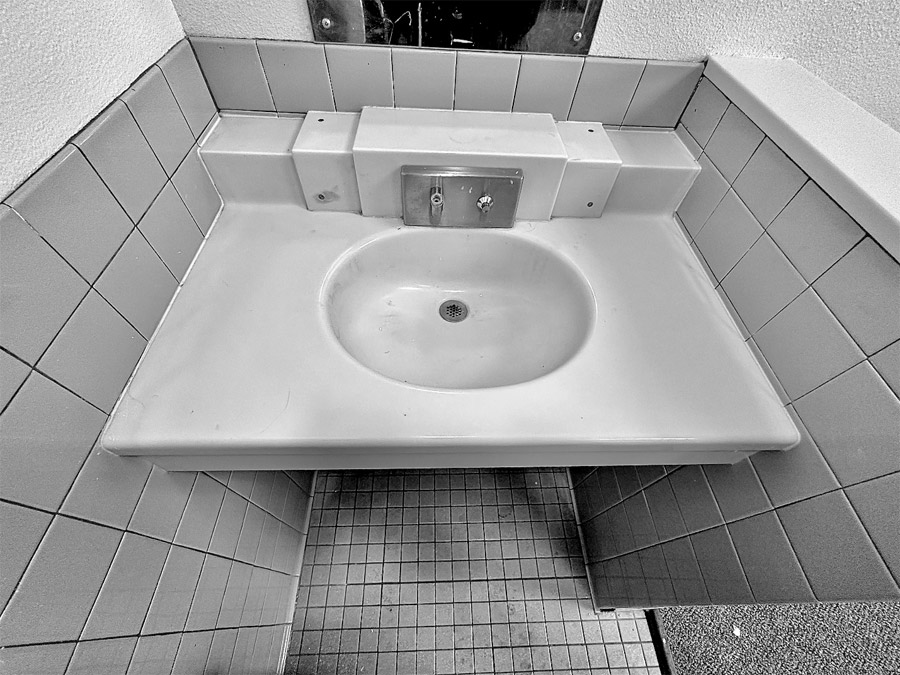 Close-up view of the sink in a double occupancy cell. Youth push a button to dispense water.