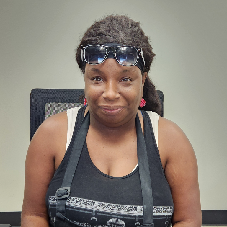 A picture of A'Tayvia-Ashwood smiling while sitting in an office chair.