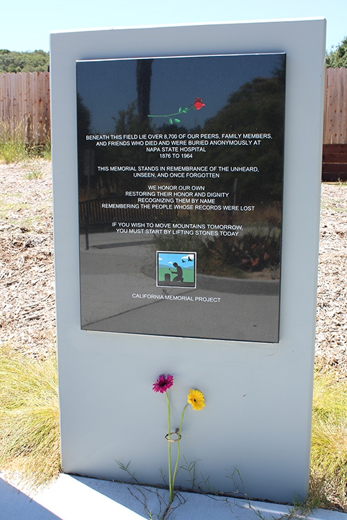 A single tall stone rectangle shaped monument in dedication to those who lived and died in state hospitals.