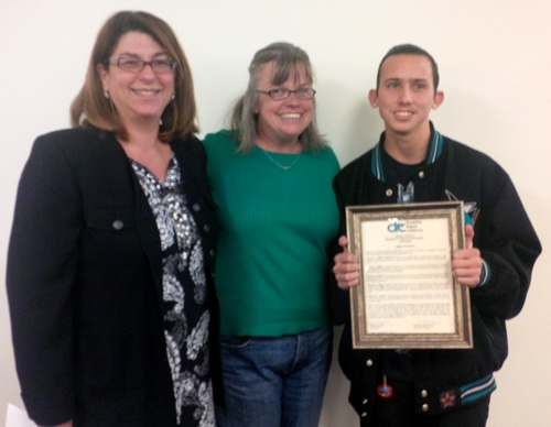 Photo of a client posing with an award with 2 DRC attorneys.