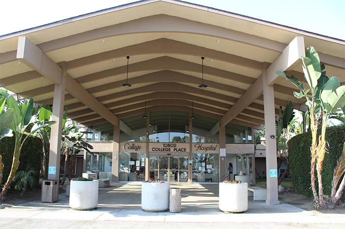 There is a large overhang that shades the walkway into the entrance to the hospital. The text on the front of the building reads, “College Hospital 10802 College Place.”