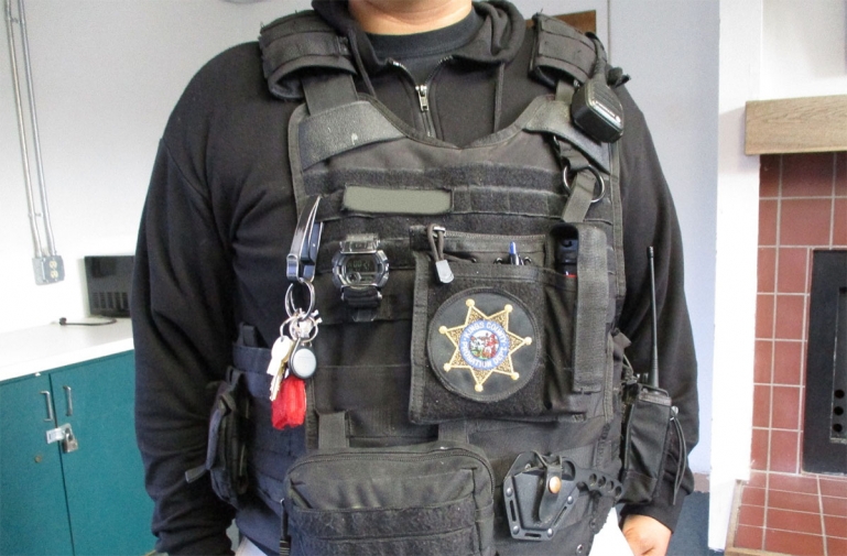 An officers in his uniform showing just the upper part of his body.