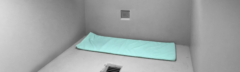 A empty cell at Otay Mesa Detention Center with only a mat on the floor for sleeping.