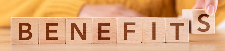 Woman Arranging Wooden Cubes and Writing Benefits Woman is arranging wooden cubes and writing word Benefits