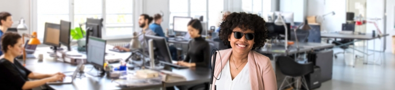 Photo of a woman who is blind working in a business office.