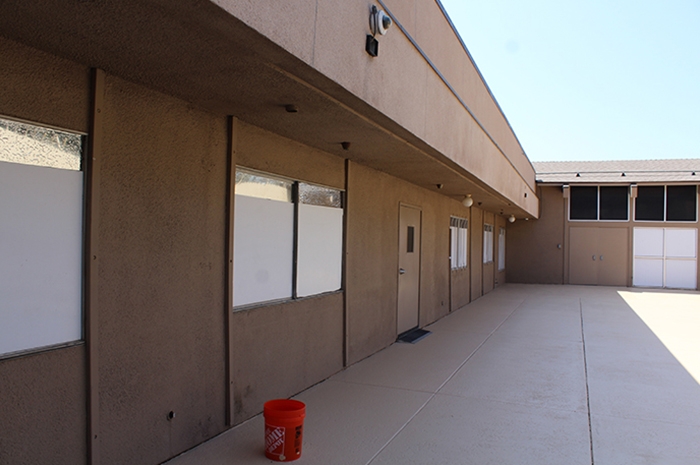 There are 5 windows along the wall that are completely covered from the outside by white paper preventing view inside or out.