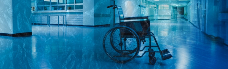 An empty wheelchair in a hospital hallway.