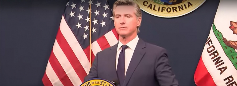 Governor Newsom at a press event behind a podium.