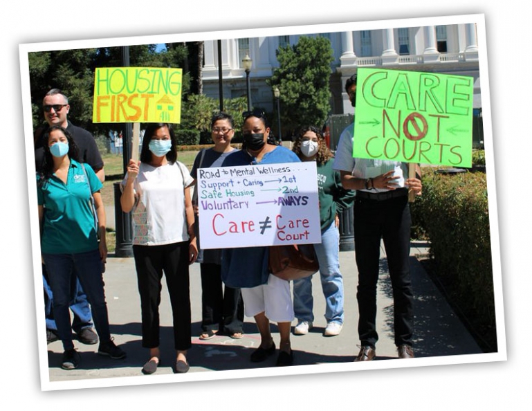 Several DRC employees holding signs up denouncing the CARE Court bill in front of the CA State Capital building.