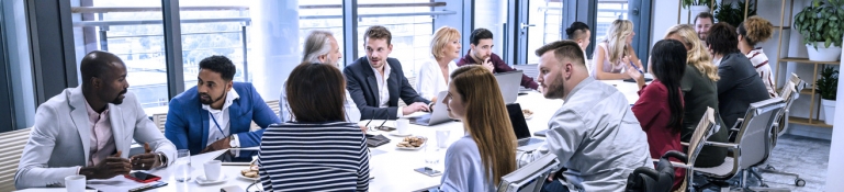 Photo of a business meeting. One employee has a disability.