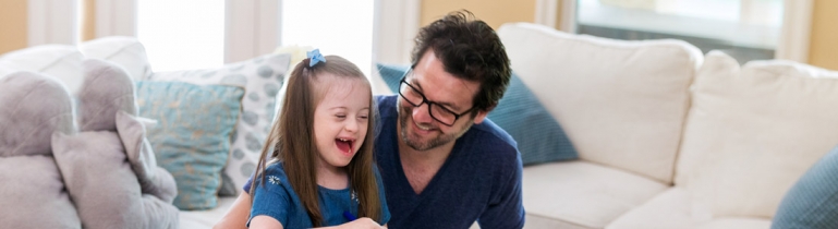 A father taking care of his daughter at home. She has a mental disability.