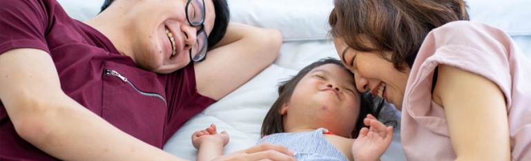 A you husband and wife with their new adopted daughter who has a disability.